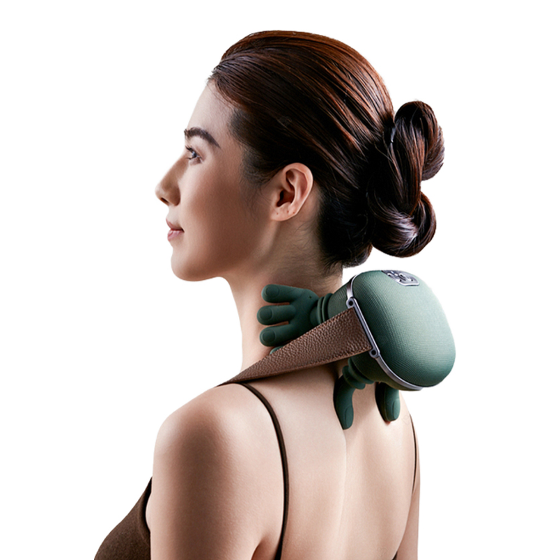 Woman using a green neck and shoulder massager on a white background